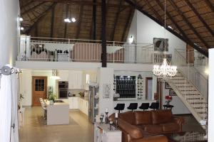 a living room with a couch and a staircase at La Barune Game Lodge in Vaalwater