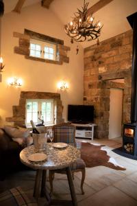 a living room with a table and a fireplace at Bluebells Cottage in Chop Gate