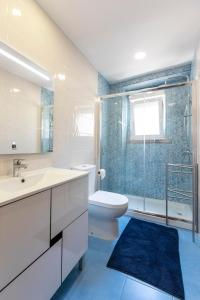 a bathroom with a sink and a toilet and a shower at Like-home Casa Campolide in Lisbon