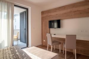 a bedroom with a bed and a table and chairs at Aparthotel Miramare in Grado