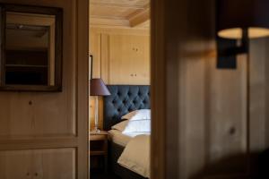 a bedroom with a bed with a blue head board at Hotel Almhof Schneider in Lech am Arlberg
