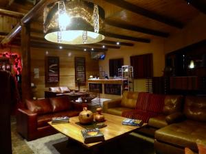 a living room with leather couches and a coffee table at Noi BordeLoa in Calama