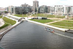 a boat traveling down a river in a city at Melia Ria Hotel & Spa in Aveiro