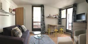 a living room with a couch and a tv at MyHome - Plein Soleil 47 - Studio cabine 4 pax skis aux pieds Val Claret in Tignes