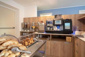 a bakery with a table with bread and acomputer at Aparthotel Miramare in Grado