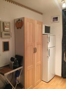 a kitchen with a white refrigerator and a door at MyHome - Plein Soleil 47 - Studio cabine 4 pax skis aux pieds Val Claret in Tignes