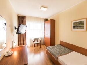 a hotel room with a bed and a tv at SPA Hotel Karelia in Petrozavodsk