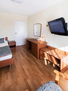 1 dormitorio con 1 cama y TV en la pared en SPA Hotel Karelia, en Petrozavodsk