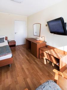 a bedroom with a bed and a television on a wall at SPA Hotel Karelia in Petrozavodsk