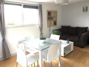 uma sala de estar com uma mesa branca e cadeiras em Cosy's Sable em Larmor-Plage