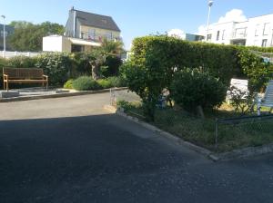 uma rua com uma cerca e um banco em frente a uma casa em Cosy's Sable em Larmor-Plage