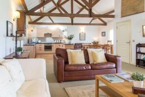 a living room with a couch and a kitchen at Beach View, Waterside Cottages in Alnmouth