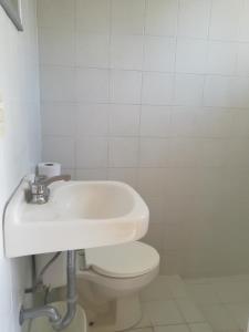 a white bathroom with a toilet and a sink at Hotel Cuauhtemoc in Quer&eacute;taro