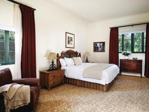 a bedroom with a bed and a chair and windows at The Langham Huntington, Pasadena in Pasadena