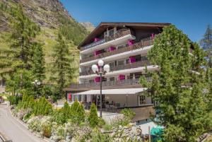 un bâtiment avec balcon sur une montagne dans l'établissement Hotel Arca Solebad & Spa, à Zermatt