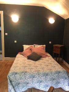 a bedroom with a large bed with two lights on it at Le Jolis Bois in Raon-lʼÉtape