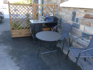 une table et des chaises à côté d'un grill, d'une table et de chaises dans l'établissement Cosy's Sable, à Larmor-Plage