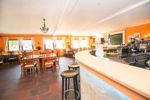 ein Restaurant mit einer Bar sowie Tischen und Stühlen in der Unterkunft Gasthof Jägerwirt in Hohenschäftlarn