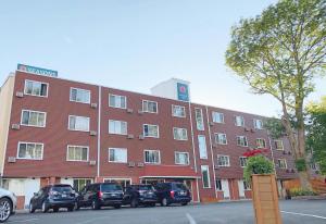 a large red building with cars parked in front of it at Seasons Inn Halifax in Halifax