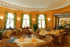 a dining room with tables and chairs and windows at Kurhotel Fürstenhof by David in Blankenburg