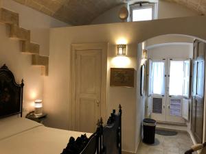 Un dormitorio con una cama y una ventana y una puerta. en “Il Mosaico” Suite Apartment - Grottaglie, en Grottaglie