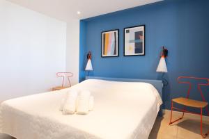 カンヌにあるMaracuja YourHostHelperの青いベッドルーム(白いベッド1台、椅子2脚付)