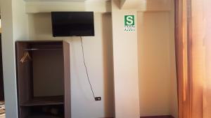 a room with a tv on the corner of a wall at Cálido Hostal in Moquegua