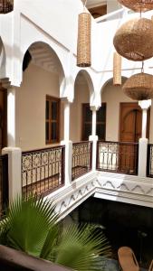 ein Gebäude mit einem Balkon und Palmen davor in der Unterkunft Riad Safina in Marrakesch