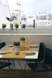uma mesa com cadeiras, pratos e copos de vinho em Hausboot Yellow submarine em Olpenitz