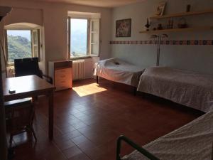 a bedroom with two beds and a desk and window at Cinqueterre - Terrace and beautiful view in Levanto