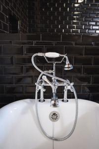 a white bath tub with a shower in a bathroom at GunRunner Boutique Hotel in Florence