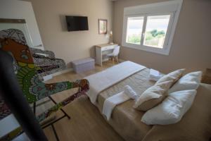 Un dormitorio con una cama grande y una ventana. en A Xanela Indiscreta, en Redondela