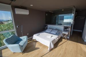 Un dormitorio con una cama y una silla azul. en A Xanela Indiscreta, en Redondela