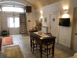 Una sala de estar con una mesa y sillas de madera. en “Il Mosaico” Suite Apartment - Grottaglie, en Grottaglie