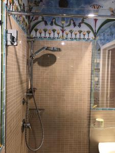 una ducha con puerta de cristal en un baño en “Il Mosaico” Suite Apartment - Grottaglie, en Grottaglie