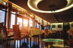 a dining room with tables and chairs in a restaurant at Hotel Lav Vukovar in Vukovar