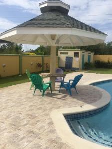 a patio with a table and chairs under a large umbrella at Driftwood 85 in Canaan