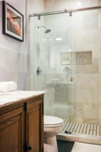 W łazience znajduje się toaleta i przeszklony prysznic. w obiekcie Renovated Historic Coconut Grove Cottage Home w Miami
