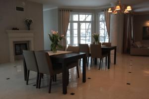 a dining room with a black table and chairs at Villa Julia in Krakow