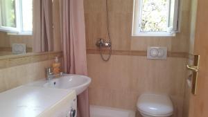 a bathroom with a sink and a toilet and a window at Family Desin Apartments in Molunat