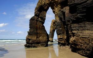 a rock formation on the beach near the ocean at A Minguxaina in Ribadeo
