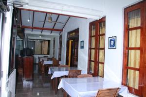 a restaurant with tables and chairs in a room at Anura Guest Inn in Ella