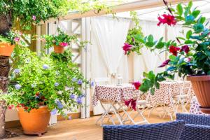 eine Terrasse mit Tischen und Stühlen mit Blumen und Pflanzen in der Unterkunft B&B La Bragadina in Lido di Venezia