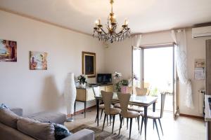 uma sala de estar com uma mesa de jantar e um lustre em Acqua di Mare em Mascali