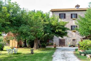 una casa in pietra con un albero nel cortile di Il Castelletto del Salamaro a Viterbo