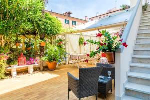 un patio con plantas, mesas y sillas en B&B La Bragadina, en Lido de Venecia