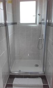 a bathroom with a shower with a glass door at Logis Hôtel Beauséjour in Chauvigny +45 photos