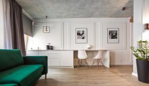 sala de estar con sofá verde y cocina en Apartament Stars, en Toruń