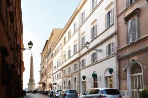 une rue avec des bâtiments et des voitures garés dans la rue dans l'établissement The Code Hotel, à Rome