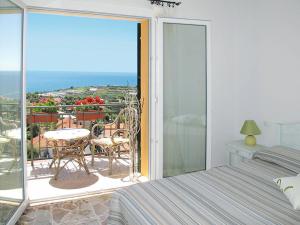 a bedroom with a balcony with a view of the ocean at Agriturismo Il Vecchio Mulino in Terzorio